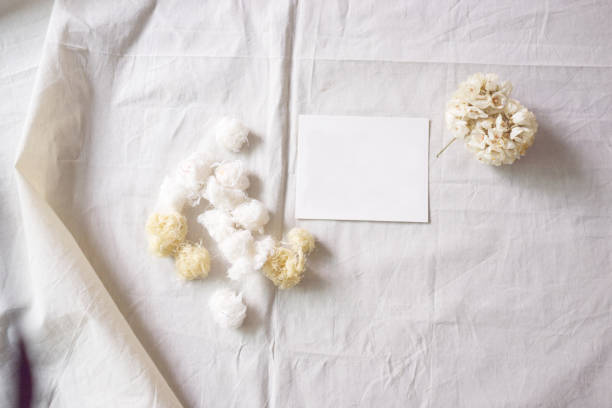 istock White paper and whit flower on white fabric , decoration background 1296776763