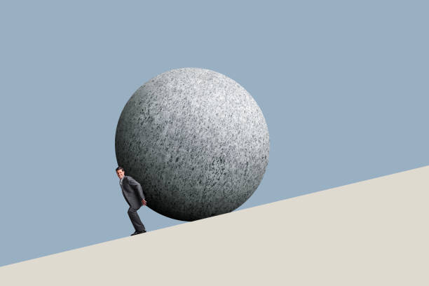 istock Businessman Pushes A Sphere Up A Hill 1296778776