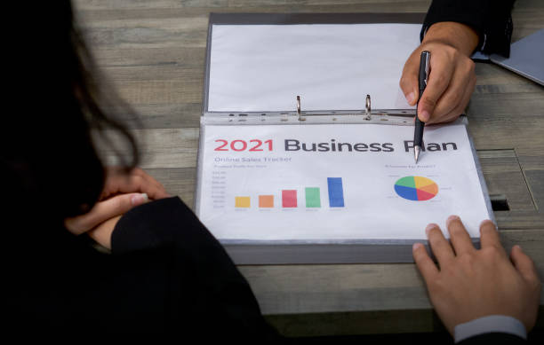 istock Business meeting on the desk at work. Human hands on a table with document, graph and  chart. 1296778993