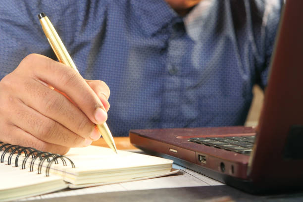istock Close up of man hand writing on notepad. 1296779662
