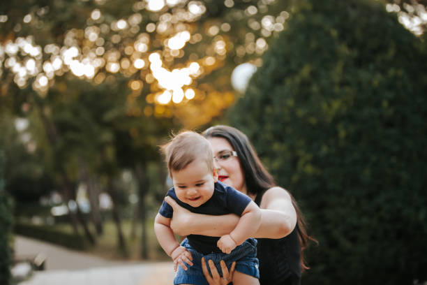 istock Mother and baby boy having fun in a park 1296781084