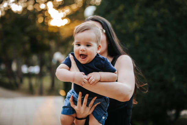 istock Mother and baby boy having fun in a park 1296781095