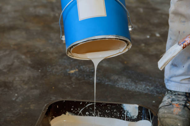 istock Pouring paint in a plastic pan with on preparing for painting 1296787436
