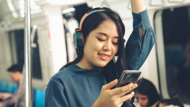 istock Young woman using mobile phone on public train 1296789077