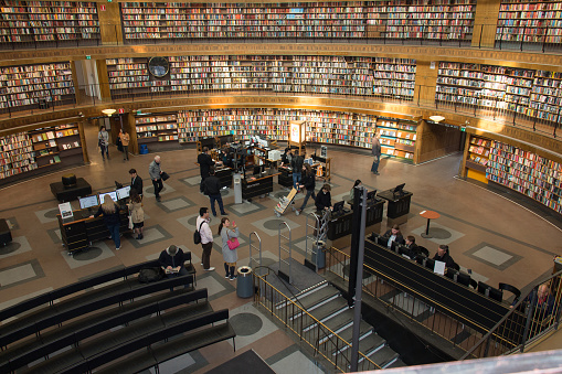Helsinki, Finland- March 22 2019: New Helsinki central library Oodi interior. Light and spacious modern northern architecture. Bookshelves, working space. People reading, working, relaxing, studying.