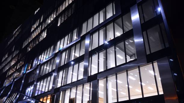 istock Pattern of office buildings windows illuminated at night. 1296794323