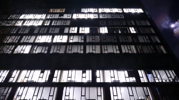 istock Pattern of office buildings windows illuminated at night. 1296795185