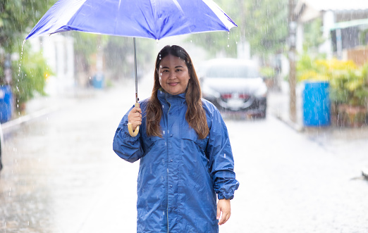 Beautiful Fat Woman Working In The Rain Asian Female Under Umbrella beautiful-fat-woman-working-in-the-rain-asian-female-under-umbrella