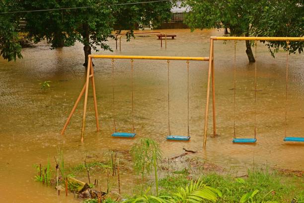 istock Playground swings with flooded ground and grass underneath 1296799824