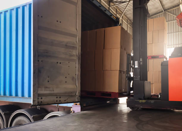 istock Cargo shipment loading for truck. Warehousing logistics and transportation, forklift driver loading cargo pallet into container truck . 1296805239