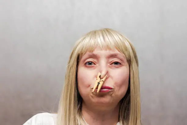 The woman covered her nose with a clothespin. The staged photo seems to have a strong smelly smell.