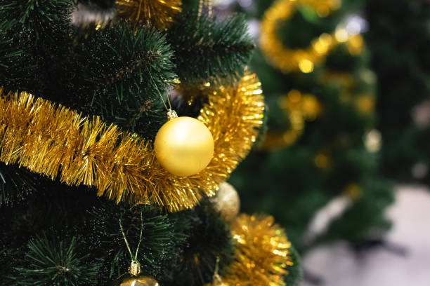 istock Yellow christmas ball on spruce close up 1296808759