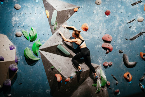 istock Strong woman climbing on boulder wall, wide angle photo 1296808947