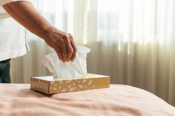 Senior women hand picking napkin/tissue paper from the tissue box Senior women hand picking napkin/tissue paper from the tissue box facial tissue stock pictures, royalty-free photos & images