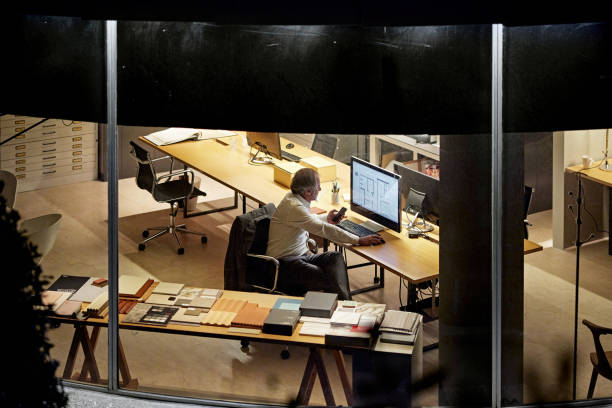 istock Mature Male Architect Working Late in Modern Office 1296811881