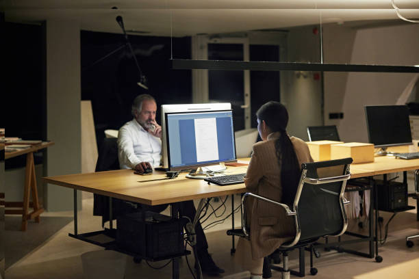 istock Diverse Corporate Colleagues Working Late in Modern Office 1296811919