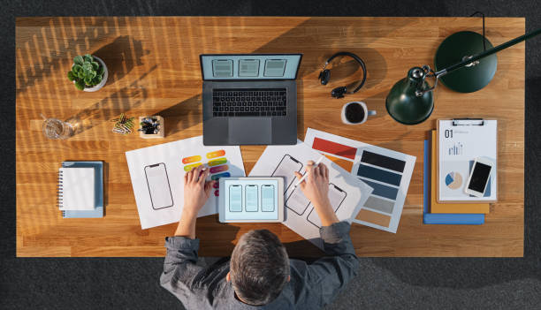 istock Top view of creative businessman working on computer at desk in home office. 1296812041