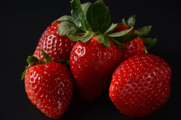 istock Strawberry fresh organic fruit. Strawberries with leaves. Isolated on a black background. 1296814313