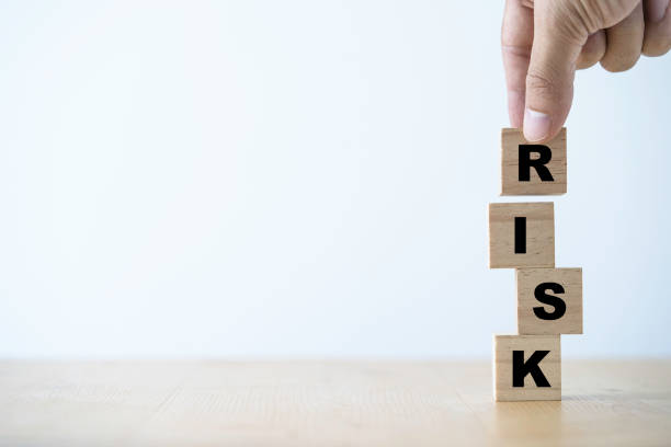 istock Risk management concept ,Hand putting wooden cube block which print screen risk wording. 1296816563