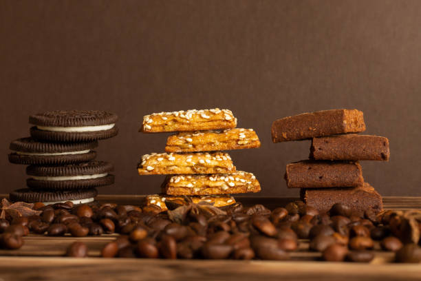 biscuits sur un fond brun d’un arbre brûlé avec des grains de café dispersés sur la table. vue latérale, espace de copie. - brown table coffee table side table photos et images de collection