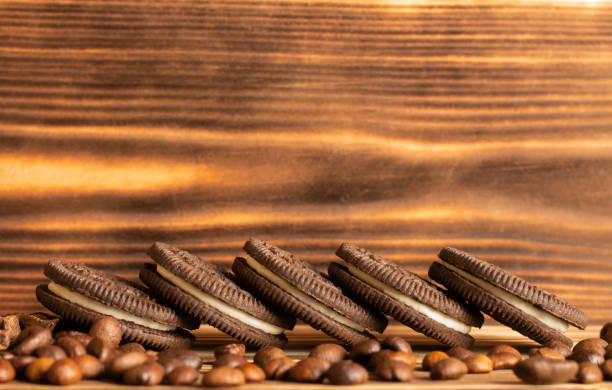 biscuits sur un fond brun d’un arbre brûlé avec des grains de café dispersés sur la table. vue latérale, espace de copie. - brown table coffee table side table photos et images de collection