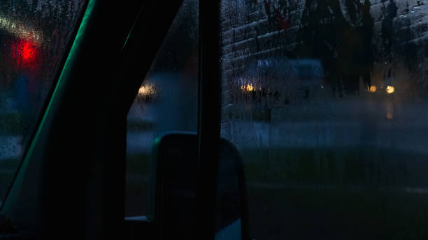 istock Side window of a car at night with raindrops 1296819853