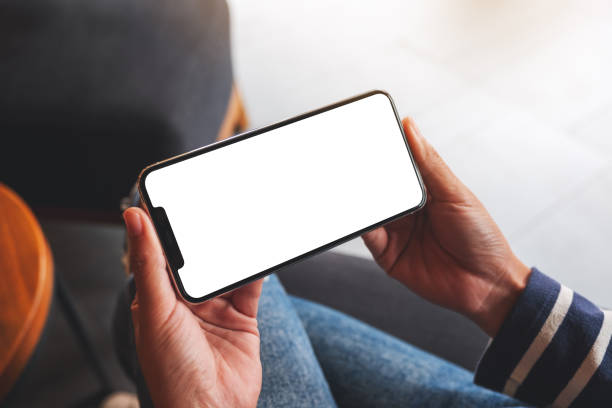 istock a woman holding mobile phone with blank white desktop screen 1296823502