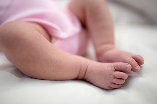 Close-up shot of small feet of a newborn baby boy sleeping
