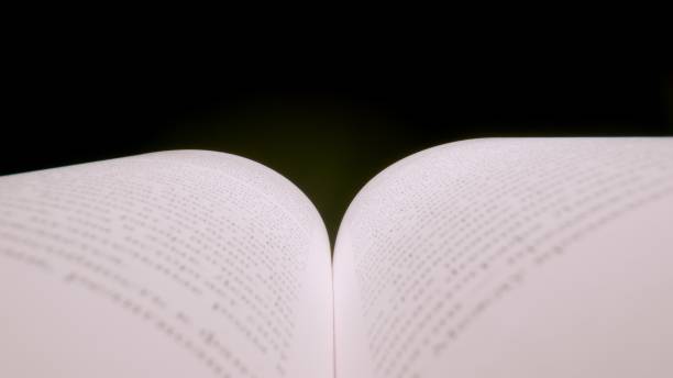 istock MACRO: Opened book. Pages and letters. Black background 1296828226