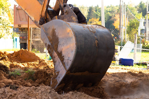 istock An excavator metal bucket digs sand or clay on a construction site while digging a trench. 1296828304