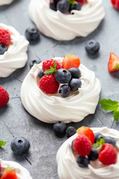 istock Meringue nest mini pavlova cake with fresh berries strawberry blueberry raspberry and mint for healthy desert. 1296830476