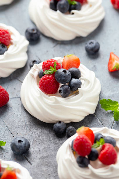 Meringue nest mini pavlova cake with fresh berries strawberry blueberry raspberry and mint for healthy desert. Meringue nest mini pavlova cake with fresh berries strawberry blueberry raspberry and mint for healthy desert serving size photos stock pictures, royalty-free photos & images