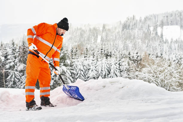 istock Snow removal, worker sweeps snow from road after winter storm 1296832738