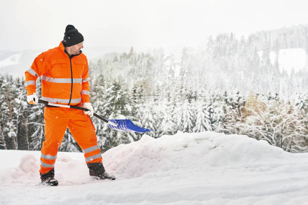 istock Snow removal, worker sweeps snow from road after winter storm 1296832776