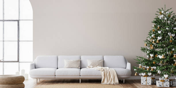 Living Room Christmas interior in Scandinavian style. Christmas tree with gift boxes. White sofa on wall Mockup