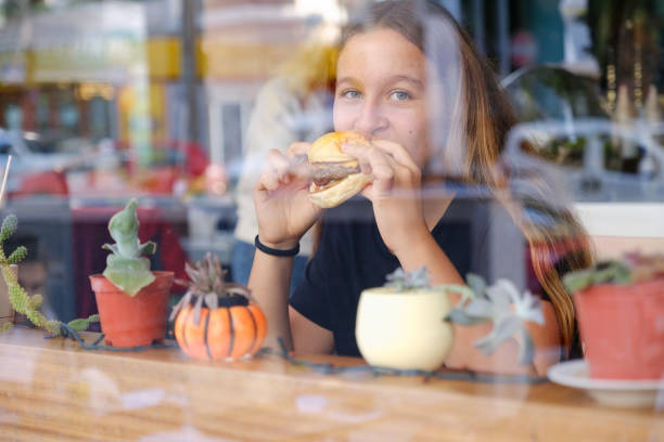 teenage girl eating a hamburger