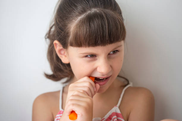 istock Cute girl biting the carrot 1296834089