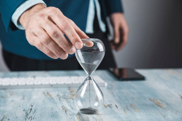 istock Businessman holding hourglass in hand 1296834385