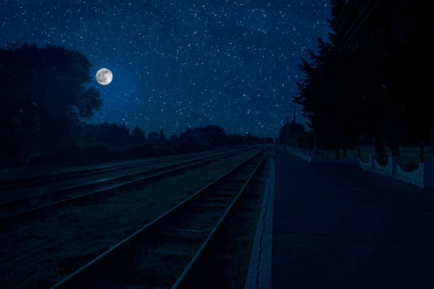 istock Empty and abandoned train station at night. Full moon over railroad. 1296836851