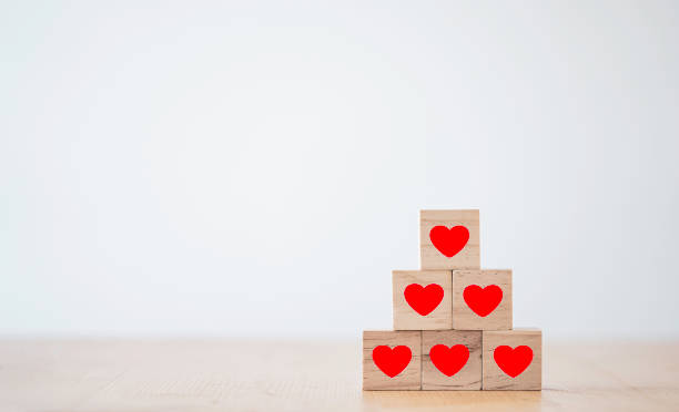 istock Valentine’s Day concept, Red heart print screen on wooden cube block and stacking on table. 1296840853