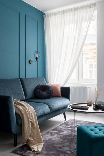 istock Stylish blue couch in small living room 1296842749
