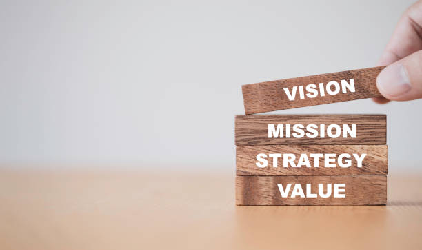 company key success concept , hand putting wooden cubes blocks which print screen vision mission strategy and value wording. - eyesight vision imagens e fotografias de stock