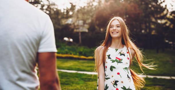 Gorgeous caucasian woman with red hair and freckles smile at her lover while playing in the park together Gorgeous caucasian woman with red hair and freckles smile at her lover while playing in the park together moldova photos stock pictures, royalty-free photos & images