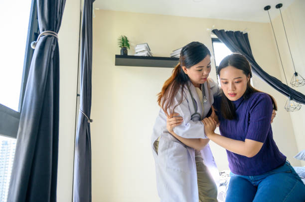 istock Physical therapist helping patient in home visit 1296844765