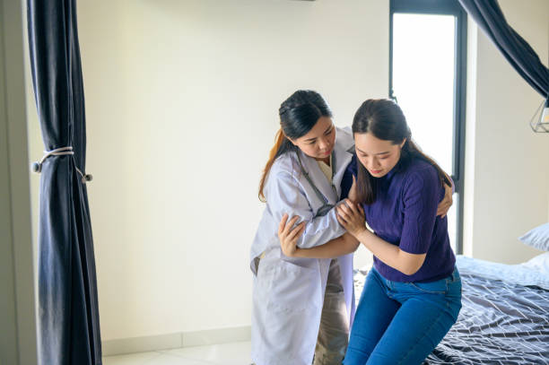 istock Physical therapist helping patient in home visit 1296844769