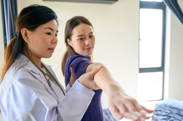 istock Physical therapist helping patient in home visit 1296844799