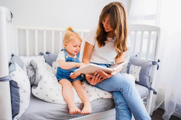 istock Young mother reads a book to her daughter before bedtime. 1296845306
