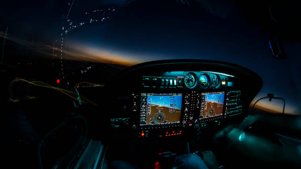 Lightened up cockpit and avionics in aircraft flying at night with beautiful twilight in background Lightened up cockpit and avionics in aircraft flying at night with beautiful twilight in background autopilot stock pictures, royalty-free photos & images