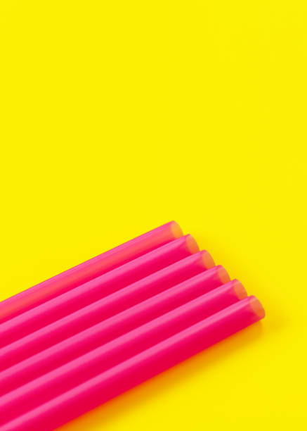 six pink plastic drinking straws on yellow board, forming diagonal line - abstract closeup detail, space for text above - drinking straw plastic design in a row imagens e fotografias de stock