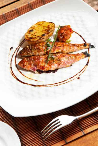 istock Grilled red mullet on plate with tomato potato and spices 1296848786